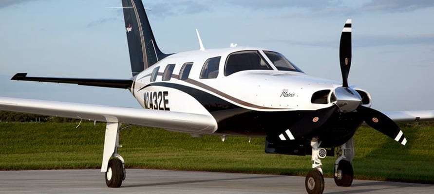 A small white and black plane on the runway.