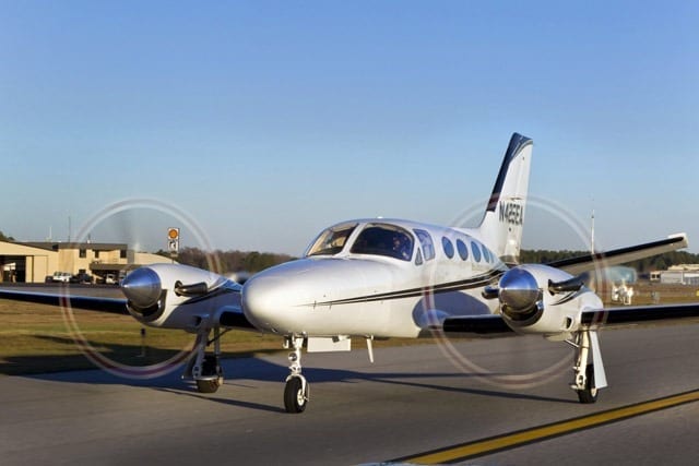 A small white airplane sitting on top of an airport runway.