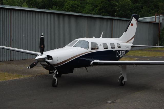 A small white and black plane sitting on top of an airport runway.